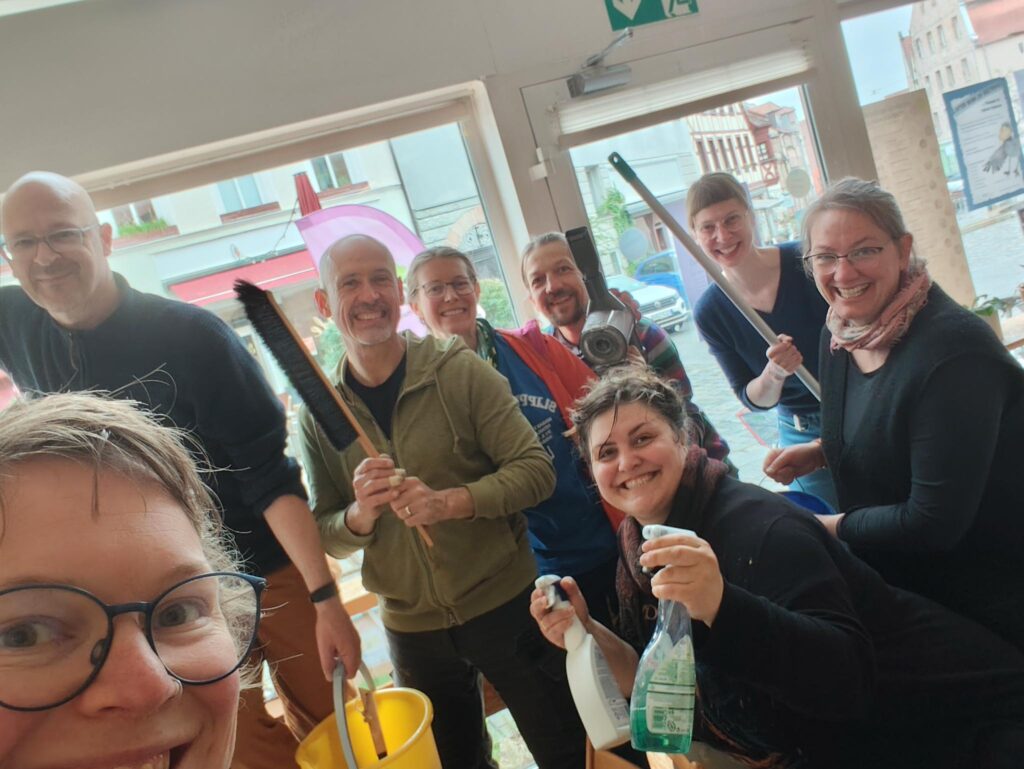 Eine Gruppe Freiwillige halten Putzutensilien in den Händen